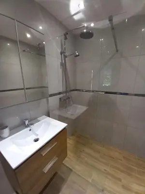 a bathroom with a white sink and a shower at Apartament przy Obozie in Oświęcim
