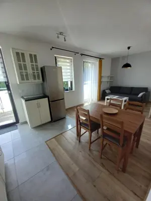 a kitchen and living room with a table and chairs at Apartament przy Obozie in Oświęcim