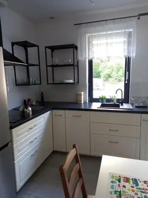 a kitchen with white cabinets and a sink and a window at Apartament przy Obozie in Oświęcim