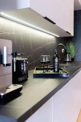 a kitchen counter with a glass of wine on a tray at Forest 21 by Housine in Zator