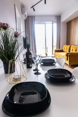 a table with two black plates and wine glasses at Forest 21 by Housine in Zator