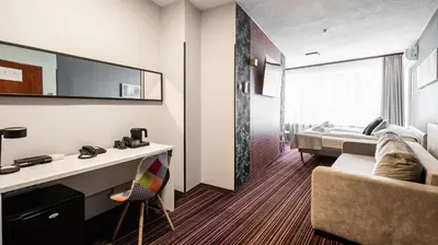 a hotel room with a couch and a bed at Hotel Delta in Kraków