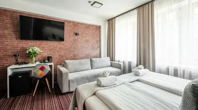 a hotel room with a bed and a couch at Hotel Delta in Kraków