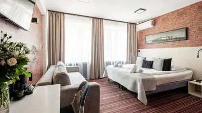 a hotel room with a bed and a couch at Hotel Delta in Kraków