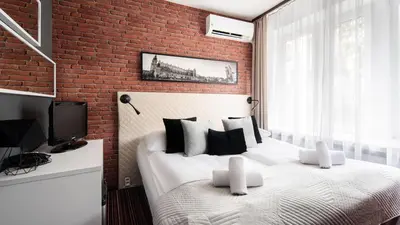 a bedroom with two beds and a brick wall at Hotel Delta in Kraków