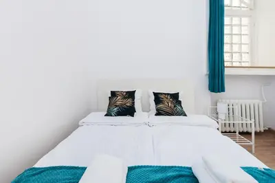 a white bed with two pillows on top of it at Szpitalna Premium Apartment in Kraków