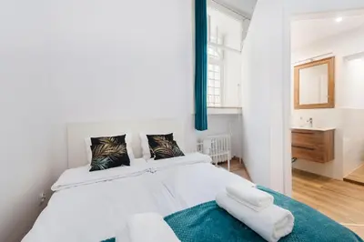 a bedroom with a large white bed with towels on it at Szpitalna Premium Apartment in Kraków