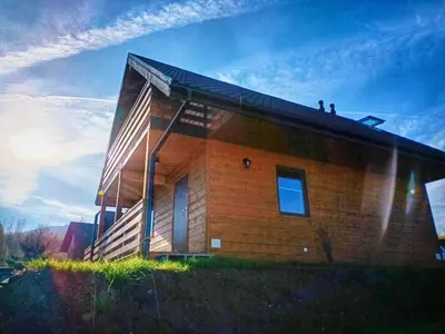 a wooden building with people sitting on top of it at Alma in Rzyki