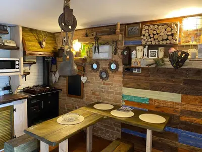 a kitchen with a wooden table with plates on it at Zielone Okiennice in Bachowice