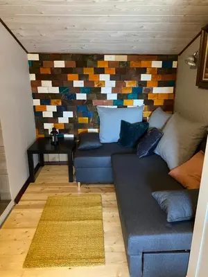 a living room with a couch and a colorful wall at Zielone Okiennice in Bachowice