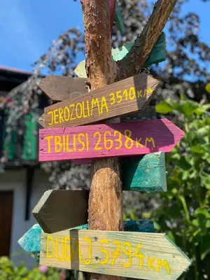a wooden sign with arrows pointing in different directions at Zielone Okiennice in Bachowice