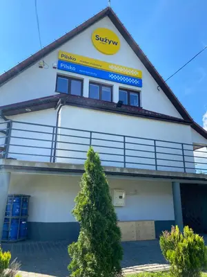 a building with a sign on the side of it at Apartamenty Suzyw Pilsko in Pewelka