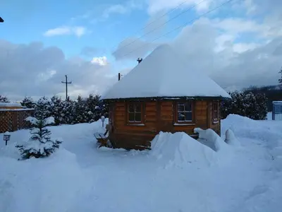 a small wooden house covered in snow at Apartamenty Suzyw Pilsko in Pewelka