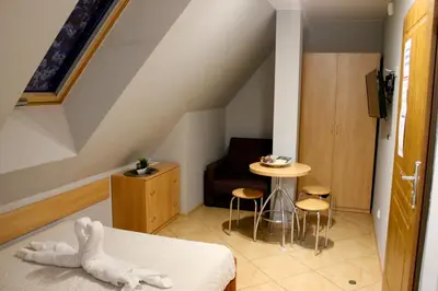 a room with a bed and a table and a chair at Apartamenty Suzyw Pilsko in Pewelka