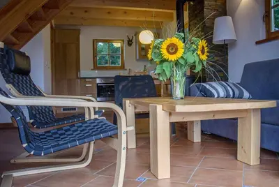 a living room with wooden ceilings and a staircase at Domki Pod Dębem in Błądzonka