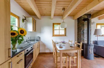 a living room with a table and a vase of sunflowers at Domki Pod Dębem in Błądzonka