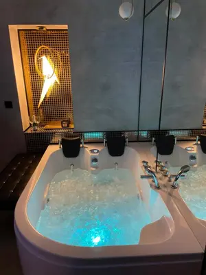 a bath tub filled with blue water in a bathroom at Apartament z Jacuzzi w Sercu Krakowa in Kraków