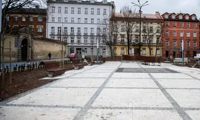a park with benches and buildings in a city at Apartament z Jacuzzi w Sercu Krakowa in Kraków
