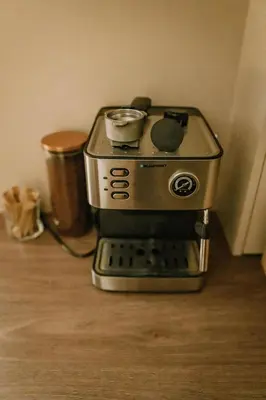 a espresso machine sitting on top of a wooden floor at Domek Bomba Zator Graboszyce in Graboszyce