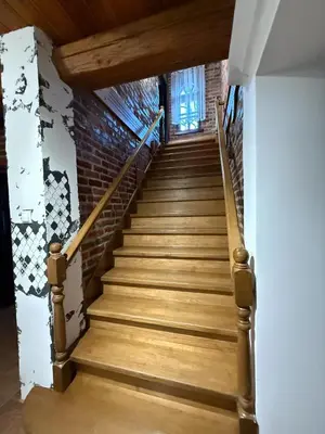 a staircase in a house with wooden floors and a brick wall at Domek Bomba Zator Graboszyce in Graboszyce
