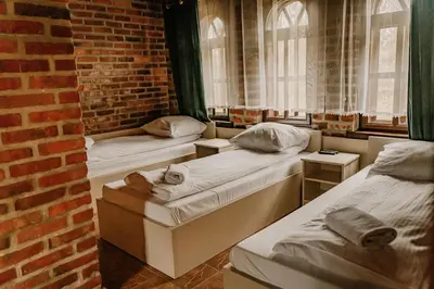 three beds in a room with a brick wall at Domek Bomba Zator Graboszyce in Graboszyce
