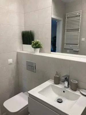 a white bathroom with a sink and a mirror at Wiślane Tarasy 2.0, free parking, private garden in Kraków