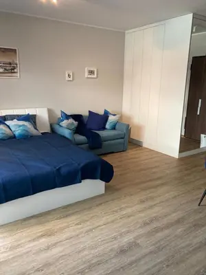 a bedroom with a blue bed and a couch at Wiślane Tarasy 2.0, free parking, private garden in Kraków