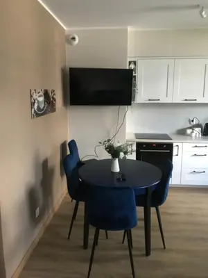 a kitchen with a black table and blue chairs at Wiślane Tarasy 2.0, free parking, private garden in Kraków
