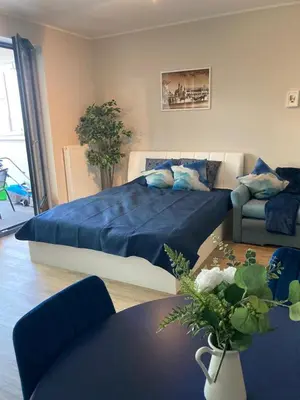 a bedroom with a large blue bed and a table at Wiślane Tarasy 2.0, free parking, private garden in Kraków