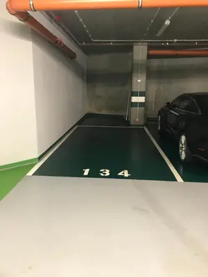 a parking garage with a car parked in it at Wiślane Tarasy 2.0, free parking, private garden in Kraków