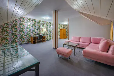 a living room with a pink couch and a table at Hotel Zalesie in Bochnia