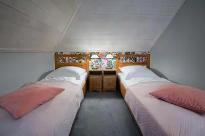 two beds in a small room with a room with windows at Hotel Zalesie in Bochnia