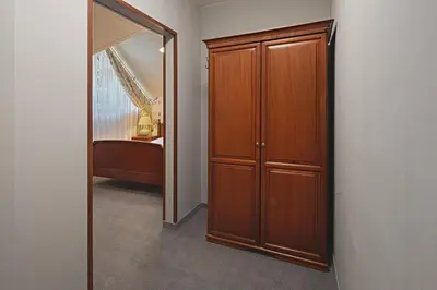 a bedroom with a wooden closet and a mirror at Hotel Zalesie in Bochnia
