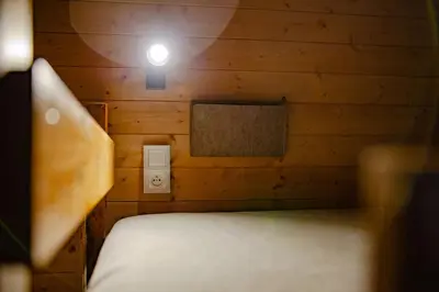 a room with a bed in a wooden cabin at Domki na Górniej Łące - Domek Słowik in Łazany