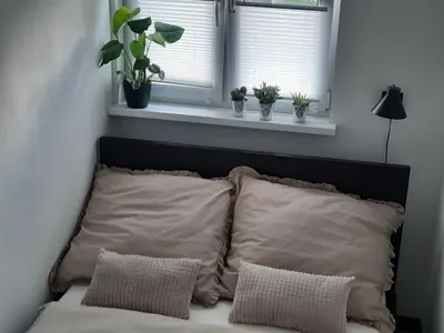 a bed with two pillows in a room with a window at GOLD&BLACK OŚWIĘCIM CENTRUM in Oświęcim