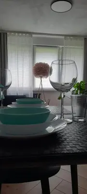 a table with green plates and wine glasses on it at GOLD&BLACK OŚWIĘCIM CENTRUM in Oświęcim
