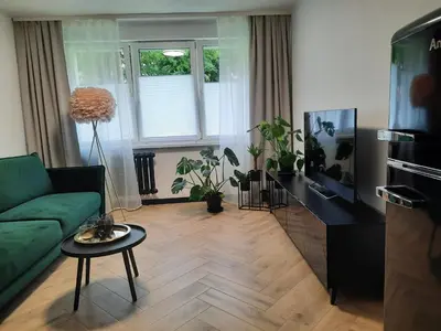 a living room with a green couch and a table at GOLD&BLACK OŚWIĘCIM CENTRUM in Oświęcim