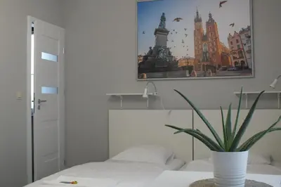 a bedroom with a plant in a vase on a bed at Apartamenty Nila in Kraków