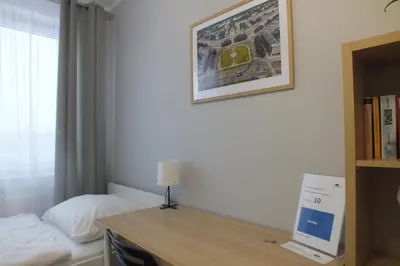 a bedroom with a bed and a desk with a computer on it at Apartamenty Nila in Kraków