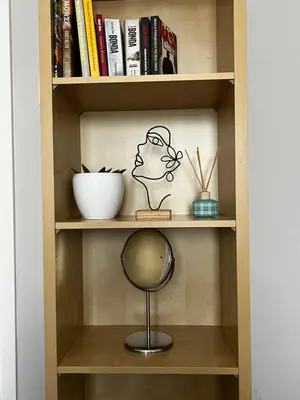 a book shelf with a mirror and books at Apartamenty Nila in Kraków