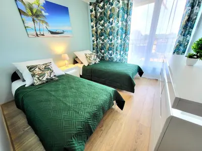 a bedroom with two green beds and a window at Eksclusive Apartment PARADISE DOWN TOWN 6 persons 3 rooms in Kraków