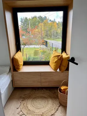 a window seat with yellow pillows in a room at Wood Lake Rożnów in Rożnów