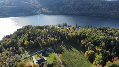 an aerial view of a house on a hill next to a lake at Wood Lake Rożnów in Rożnów