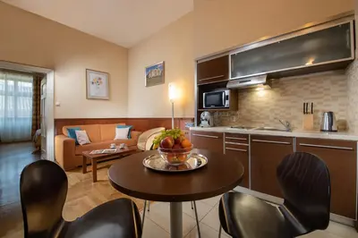 a kitchen and a living room with a table and chairs at Red Brick Apartments in Kraków