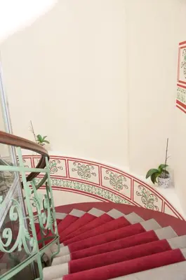 a staircase with a red carpet and a railing at Red Brick Apartments in Kraków