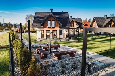 a house with picnic tables in front of it at Dolina Barw - całoroczne domki na wynajem in Rabka