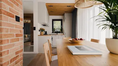 a kitchen and dining room with a table with a tablet on it at Dolina Barw - całoroczne domki na wynajem in Rabka