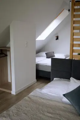 a bedroom with two beds and a sloped ceiling at Gorczańskie Wzgórze in Niedźwiedź