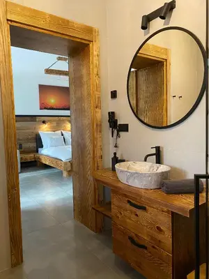 a bathroom with a sink and a mirror and a bed at Apartamenty Zander in Zator