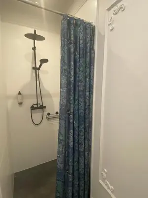 a bathroom with a shower curtain in a room at Kraków Green Hill Luxury Apartment in Balice